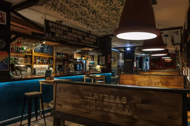 Vista general del bar con bancos de madera y una barra