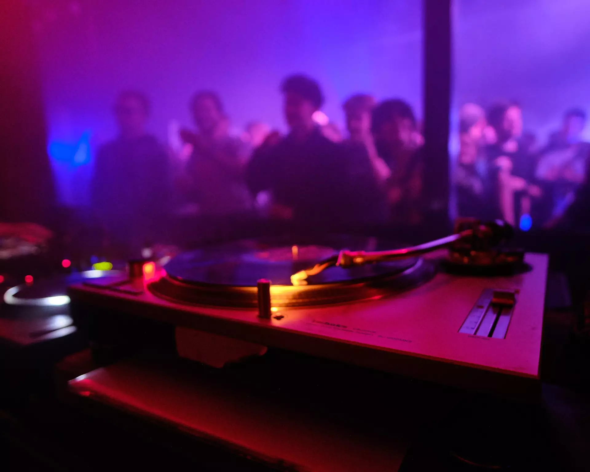 Plato de discos y personas bailando